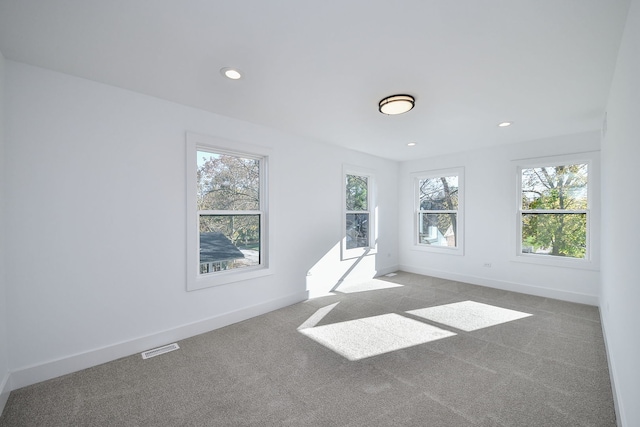 unfurnished room featuring light carpet