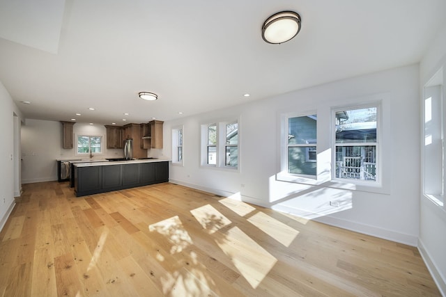 kitchen featuring dark brown cabinets, kitchen peninsula, and light hardwood / wood-style flooring