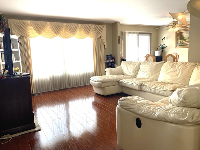 living room featuring ceiling fan and dark hardwood / wood-style floors