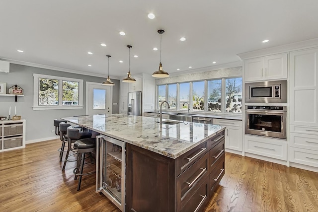 627 68th St, Willowbrook, IL 60527 - kitchen with beverage cooler, white cabinets, and appliances with stainless steel finishes