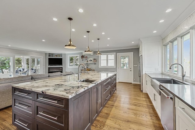 627 68th St, Willowbrook, IL 60527 - kitchen featuring a sink, white cabinets, open floor plan, and stainless steel appliances