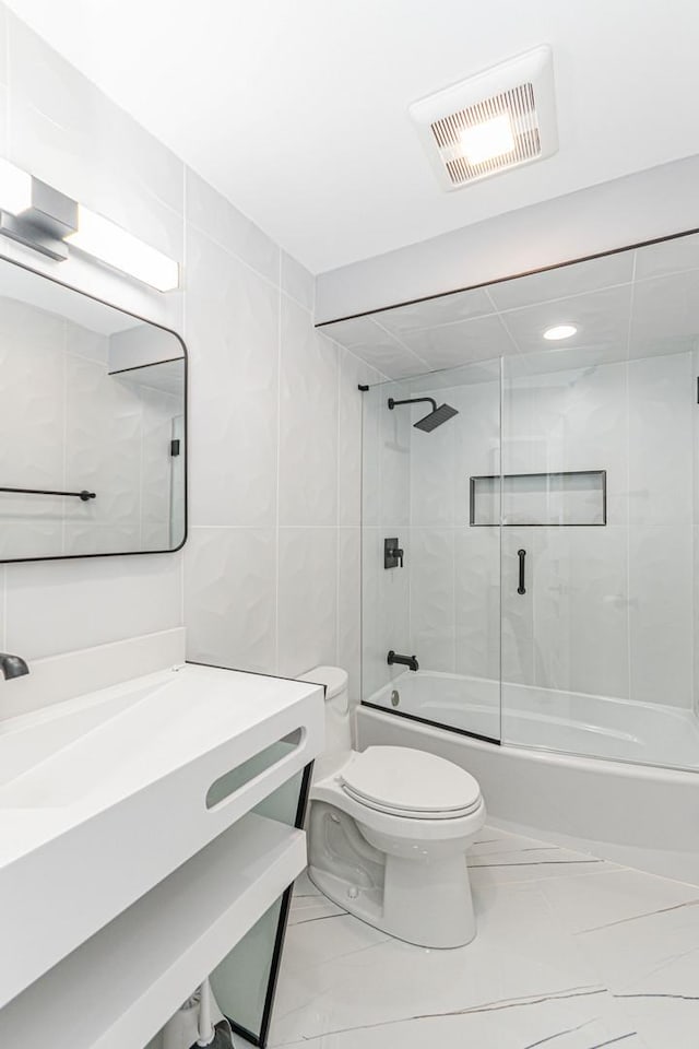 full bathroom featuring enclosed tub / shower combo, vanity, and toilet