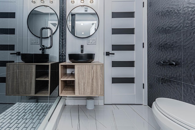 bathroom featuring vanity, toilet, and tile walls