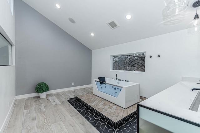 bathroom featuring wood-type flooring and vaulted ceiling