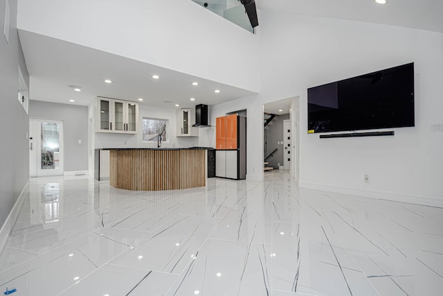 unfurnished living room featuring a towering ceiling