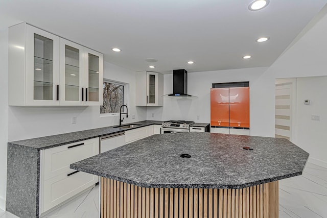 kitchen featuring white cabinetry, sink, a large island, and wall chimney range hood