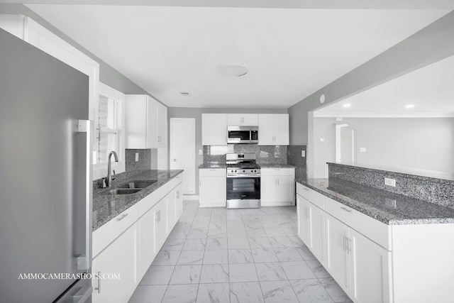 kitchen featuring stainless steel appliances, a sink, white cabinetry, marble finish floor, and tasteful backsplash