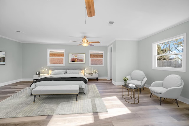 bedroom featuring multiple windows, baseboards, and wood finished floors