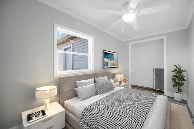 bedroom with a ceiling fan, crown molding, baseboards, and wood finished floors