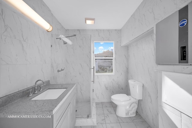 bathroom featuring a marble finish shower, toilet, marble finish floor, vanity, and tile walls