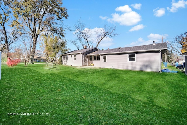 rear view of property featuring a lawn and a chimney