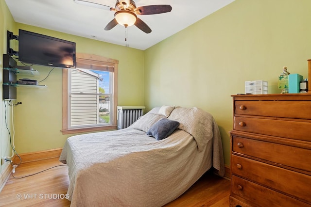 bedroom featuring baseboards, wood finished floors, and ceiling fan