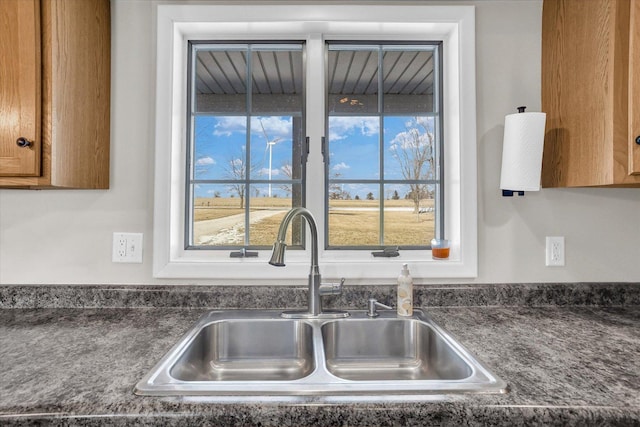 kitchen featuring dark countertops, a sink, and brown cabinets