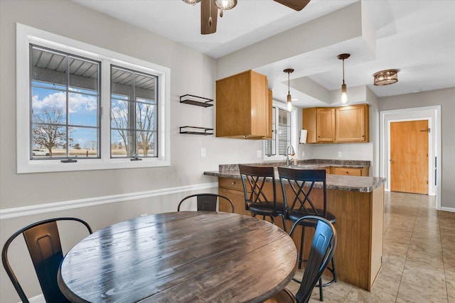 dining area with ceiling fan and baseboards