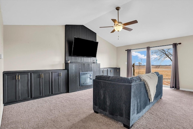 living area featuring baseboards, light colored carpet, ceiling fan, vaulted ceiling, and a fireplace