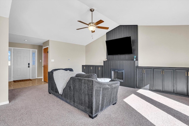 carpeted living area with a fireplace, vaulted ceiling, baseboards, and ceiling fan