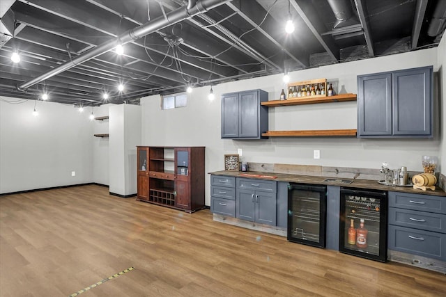 bar with a dry bar, light wood-type flooring, beverage cooler, and baseboards