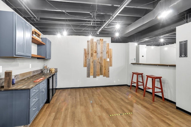 kitchen featuring dark countertops, light wood-style floors, blue cabinets, and open shelves