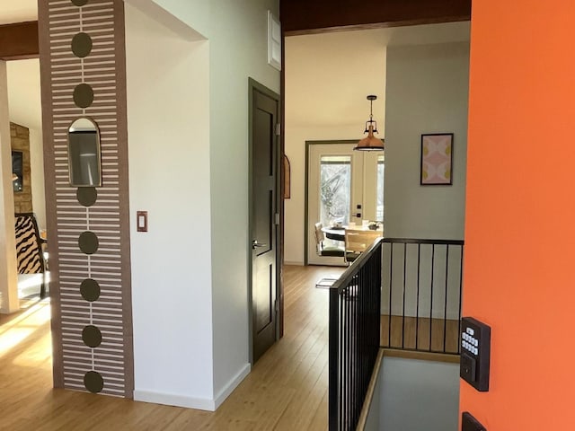 corridor with light wood-type flooring, baseboards, an upstairs landing, and french doors