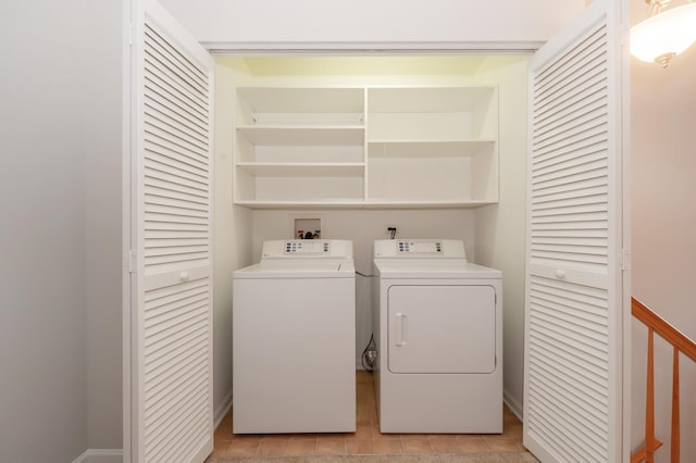 clothes washing area with independent washer and dryer and light tile patterned floors