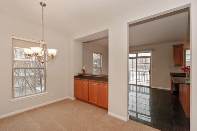 unfurnished dining area featuring an inviting chandelier and light carpet