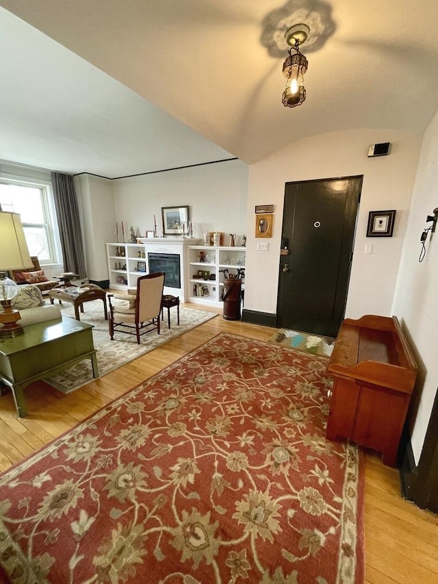 entrance foyer with a fireplace, vaulted ceiling, and hardwood / wood-style floors