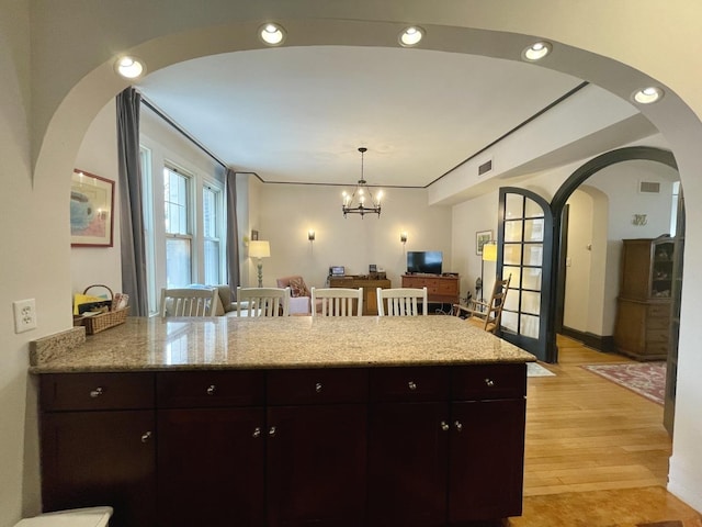 kitchen with light wood-style floors, recessed lighting, a peninsula, and light stone counters