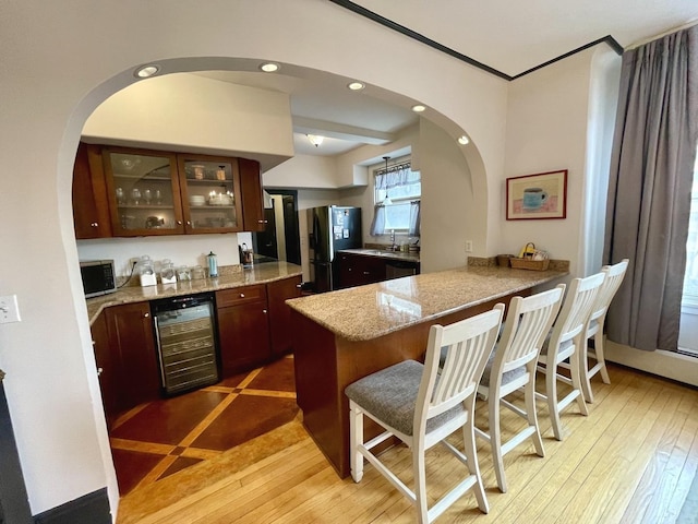 bar featuring recessed lighting, beverage cooler, light wood-style flooring, and a dry bar