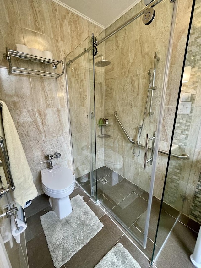 bathroom with a stall shower, tile patterned flooring, crown molding, and tile walls