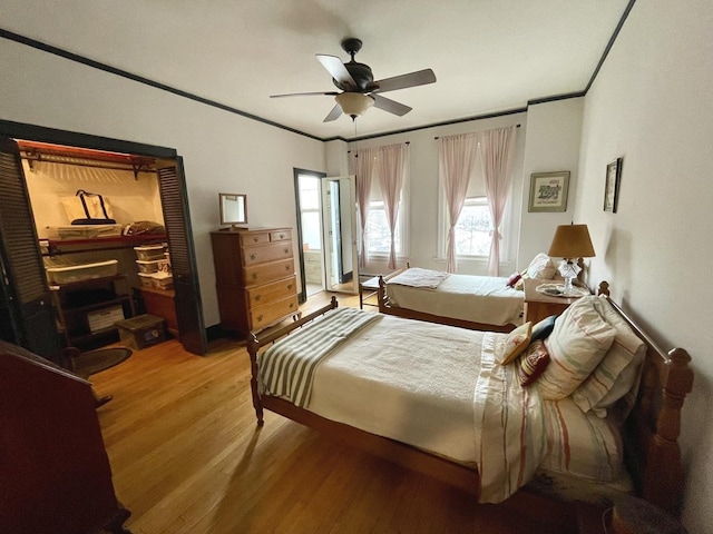 bedroom with ornamental molding, light wood-type flooring, and ceiling fan