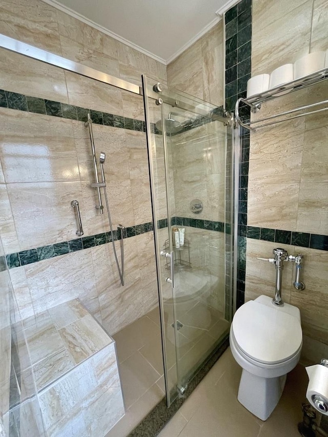 full bath featuring toilet, ornamental molding, tile patterned floors, a shower stall, and tile walls