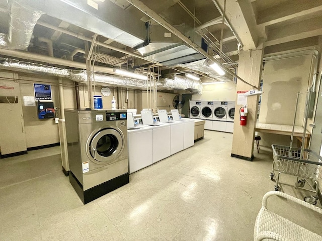 common laundry area with washing machine and clothes dryer and tile patterned floors