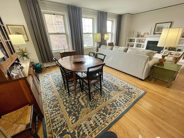 dining space featuring light wood-style floors and a fireplace