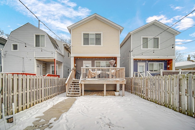 rear view of house with a deck, stairway, and a fenced backyard