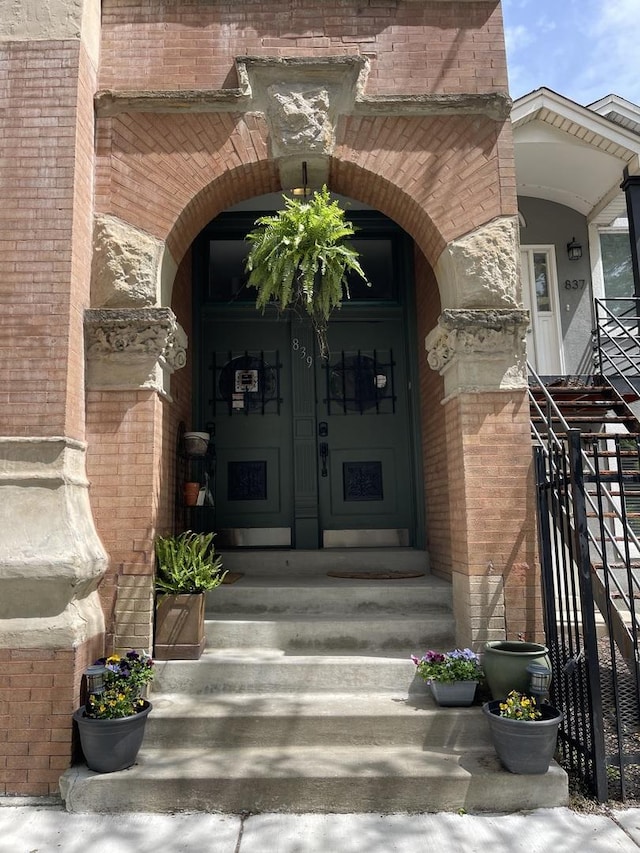 entrance to property featuring brick siding