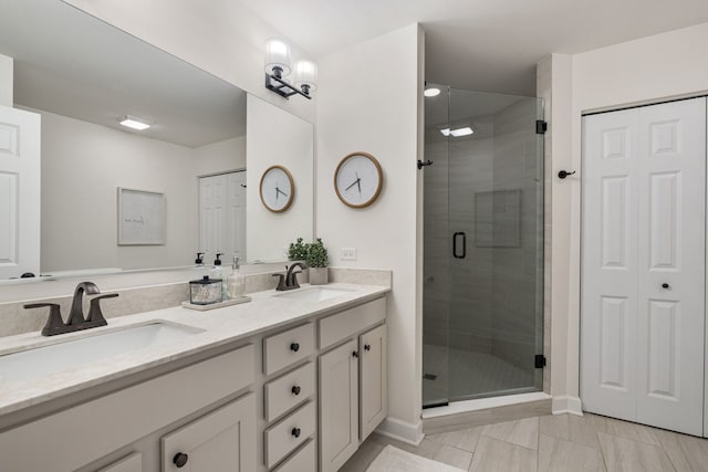 bathroom with a shower with shower door and vanity