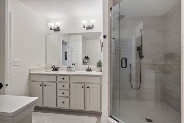 bathroom featuring a shower with shower door and vanity