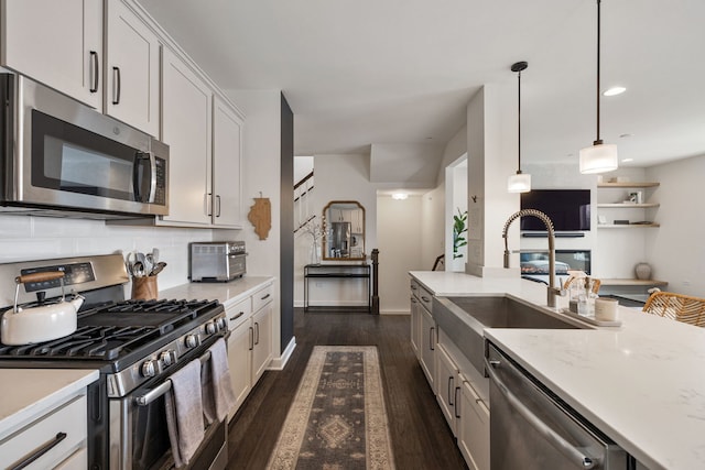 kitchen featuring decorative light fixtures, sink, tasteful backsplash, appliances with stainless steel finishes, and white cabinets