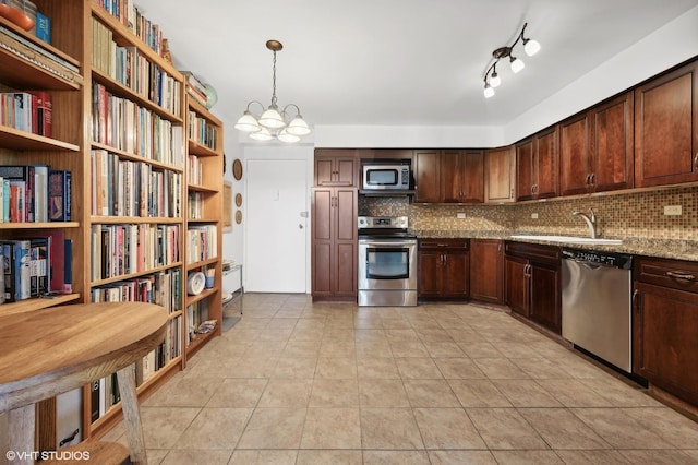 kitchen with sink, light stone counters, hanging light fixtures, light tile patterned floors, and appliances with stainless steel finishes