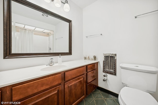 bathroom featuring vanity, heating unit, and toilet