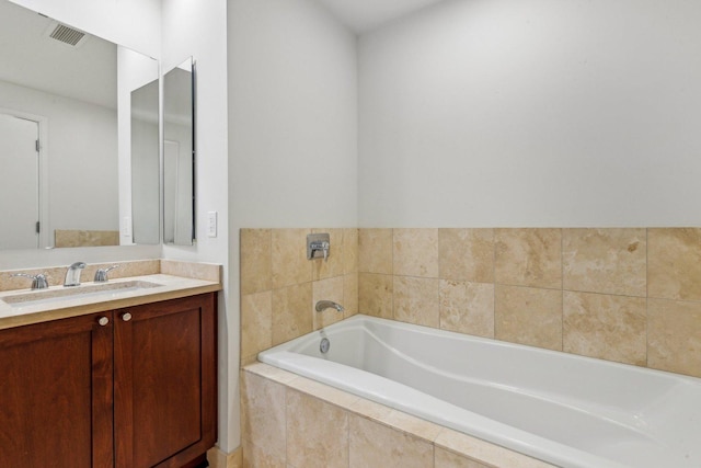 bathroom with vanity and tiled tub