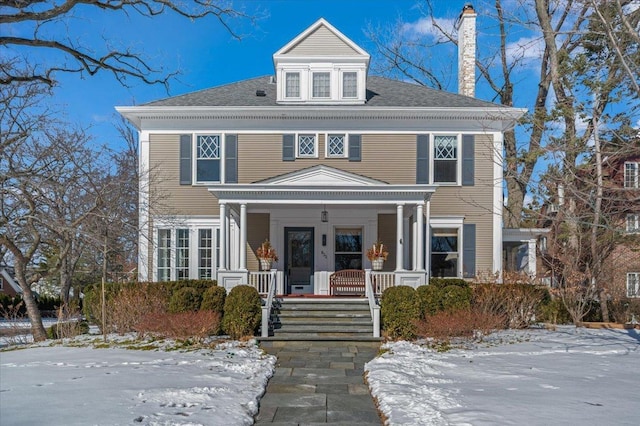 traditional style home with a porch and a chimney