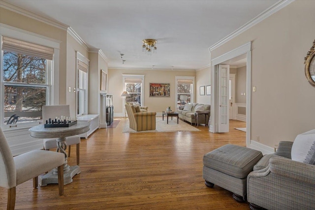 sitting room featuring ornamental molding, baseboards, and wood finished floors