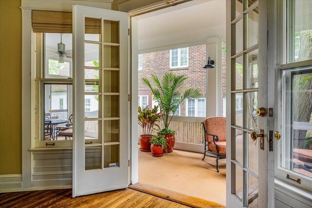 doorway with a ceiling fan, french doors, and wood finished floors