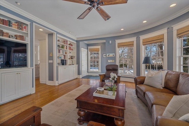 living room featuring ceiling fan, ornamental molding, and wood finished floors