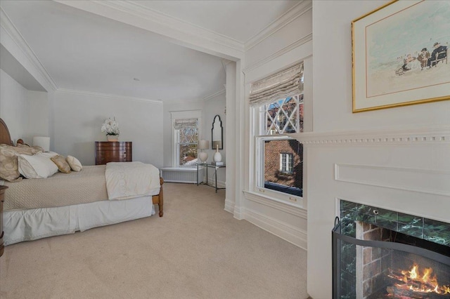 bedroom featuring carpet floors, a lit fireplace, ornamental molding, and baseboards