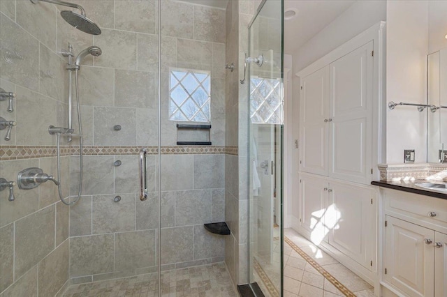 full bathroom featuring a stall shower, vanity, and tile patterned floors