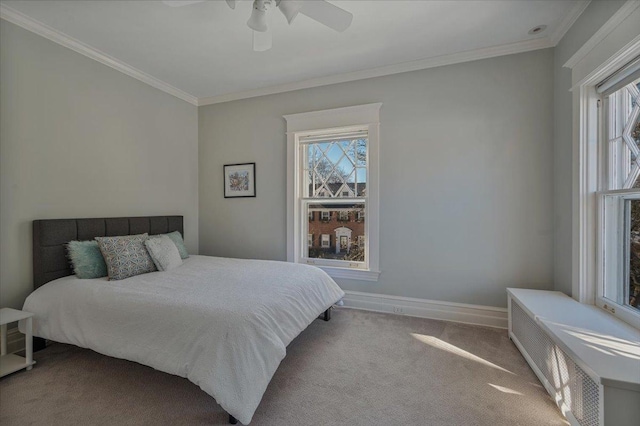 carpeted bedroom featuring a ceiling fan, baseboards, and crown molding