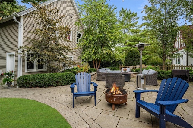 view of patio featuring an outdoor living space with a fire pit and fence