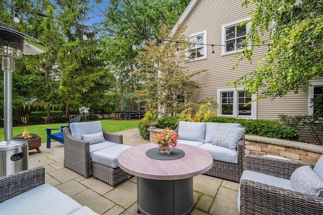 view of patio / terrace with a trampoline, an outdoor living space with a fire pit, and fence